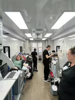A blood donor receiving care inside the Vitalant mobile bus